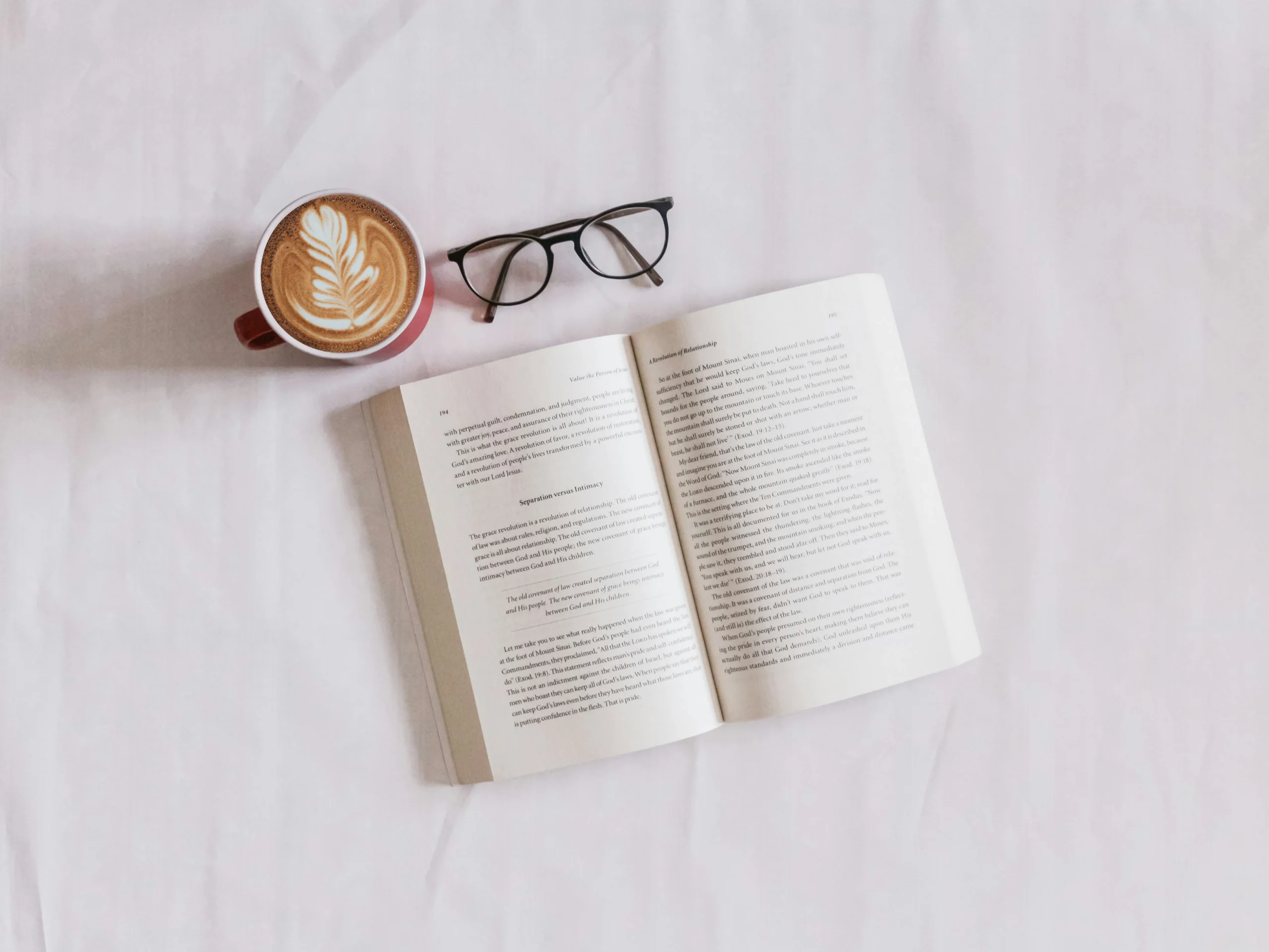 libro-en-la-cama-con-cafe-y-gafas